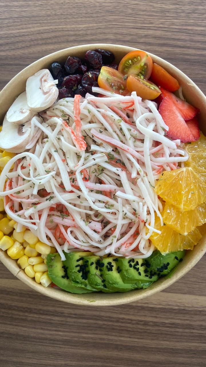 Fresh crab stick salad bowl with avocado and seasonal fruits